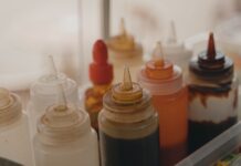 Podstawowe sosy azjatyckie w kuchni domowej: przewodnik dla początkujących Butelki z sosami w dozownikach na kuchennym blacie
