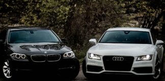 Czarne BMW i białe Audi sedan zaparkowane na żwirowej drodze outdoors