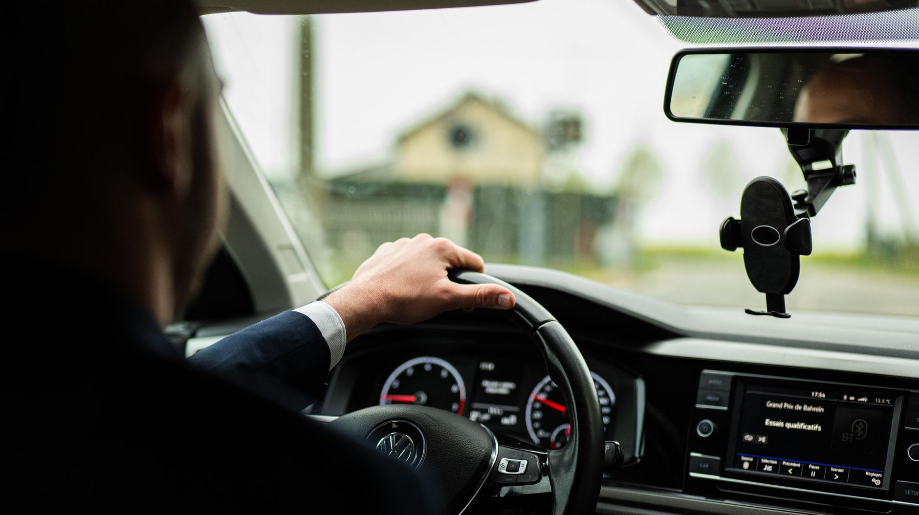 Kierowca w garniturze prowadzi nowoczesne auto Volvo z widokiem na deskę