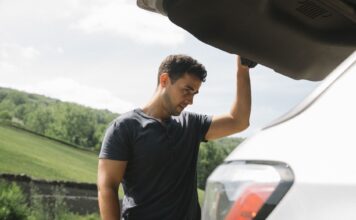 Mężczyzna sprawdza bagażnik samochodu przed długą trasą