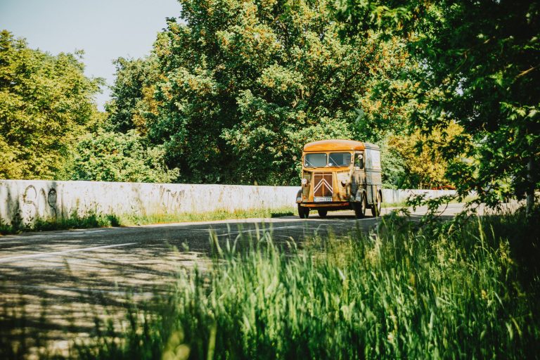 Klasyczny van Citroën jadący malowniczą drogą wśród zieleni